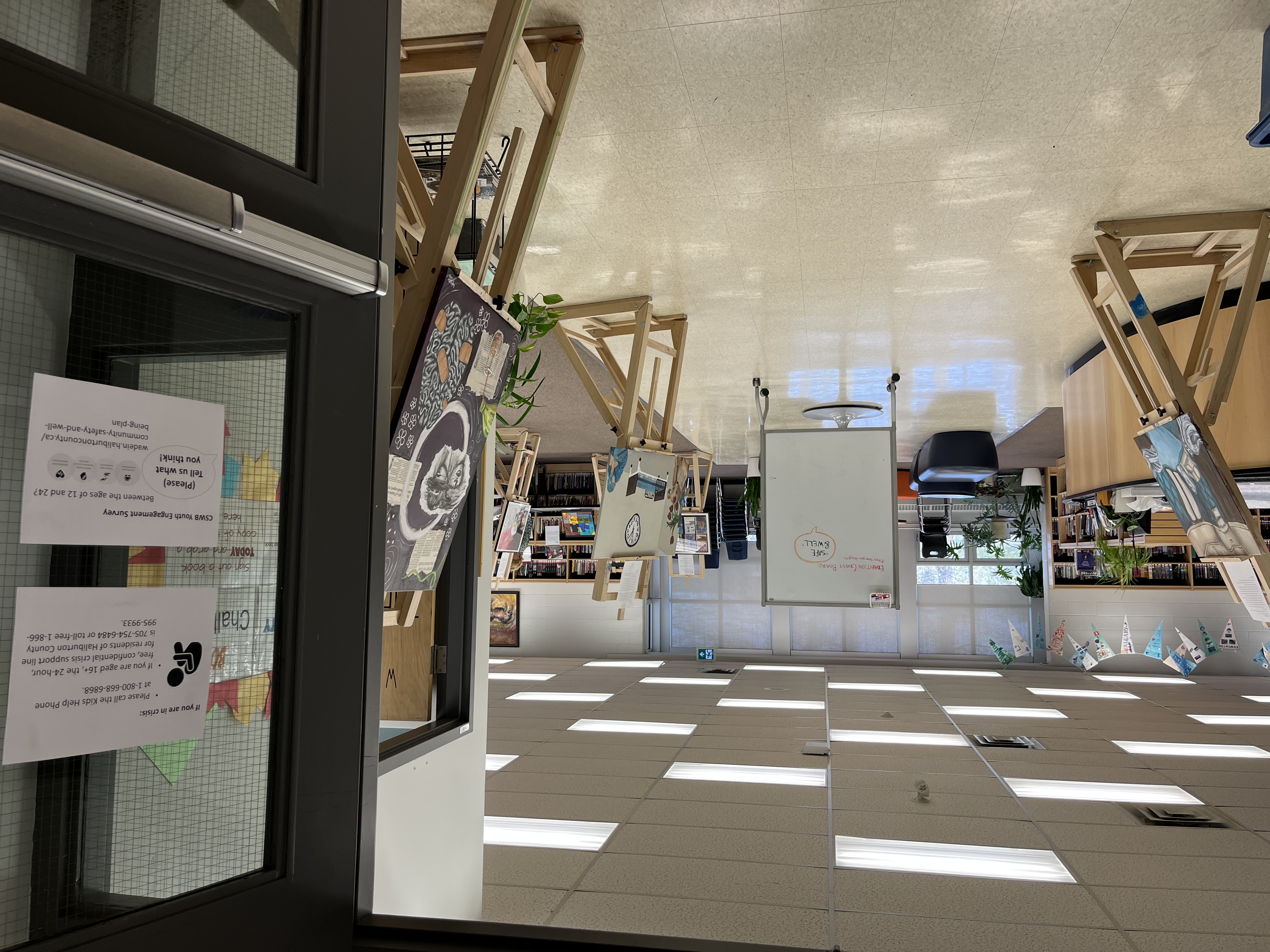 The entrance to the in-person CSWB Youth Art Exhibition held at HHSS on May 10. Artwork arranged on easels can be seen in foreground and background.