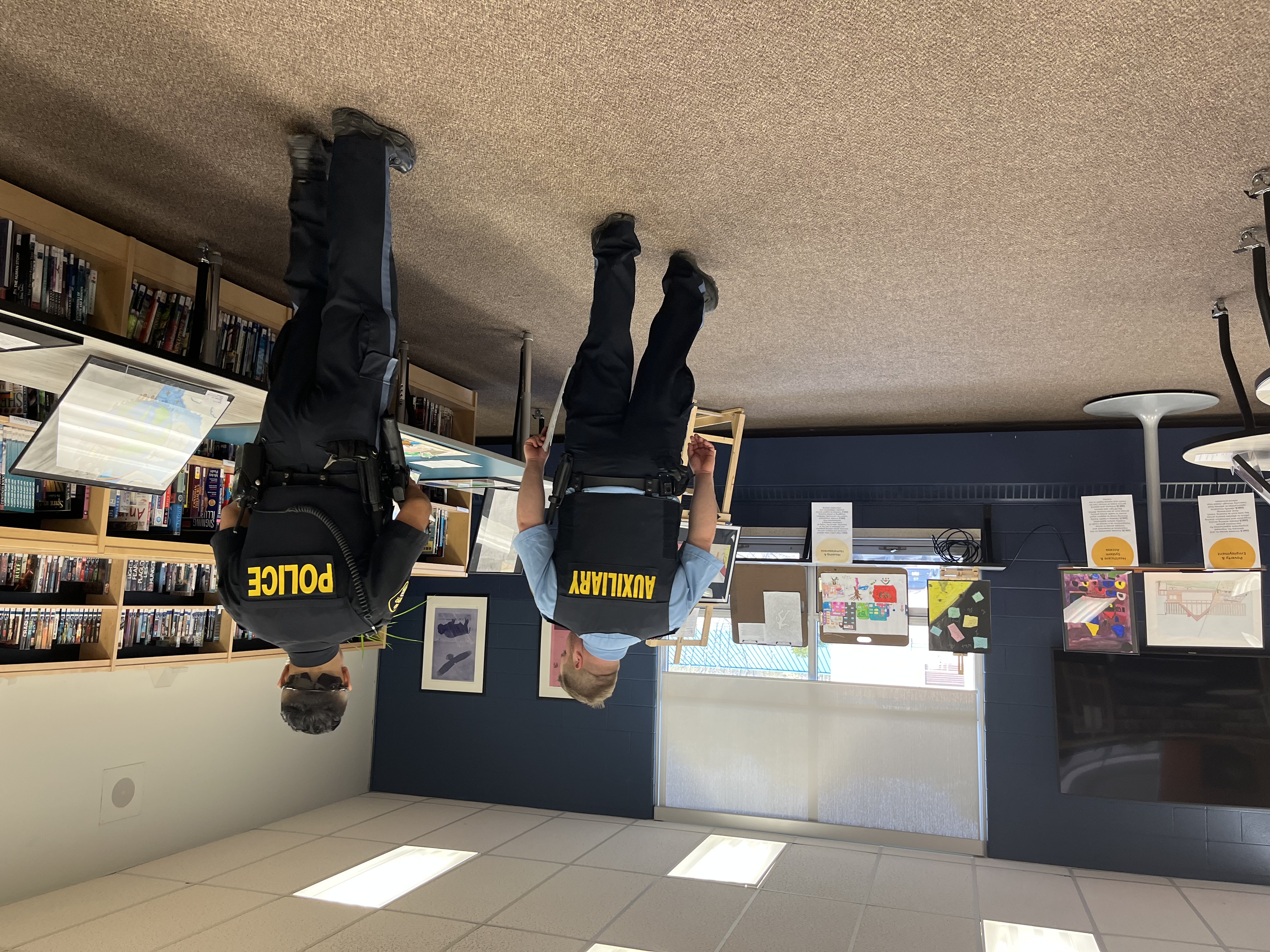 A police officer and auxiliary officer view the CSWB Youth Art Exhibition held at HHSS on May 10. 