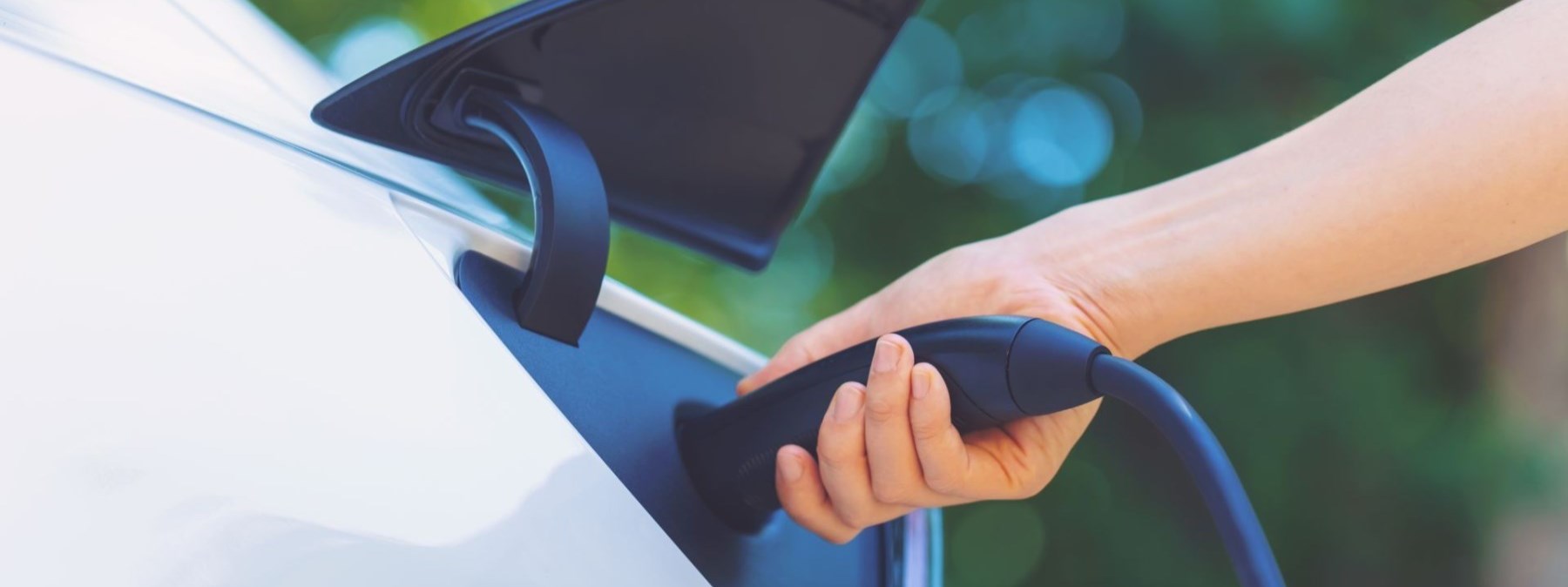 Person charging an electric vehicle