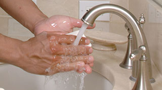 hands washing with soap at a bathroom sink