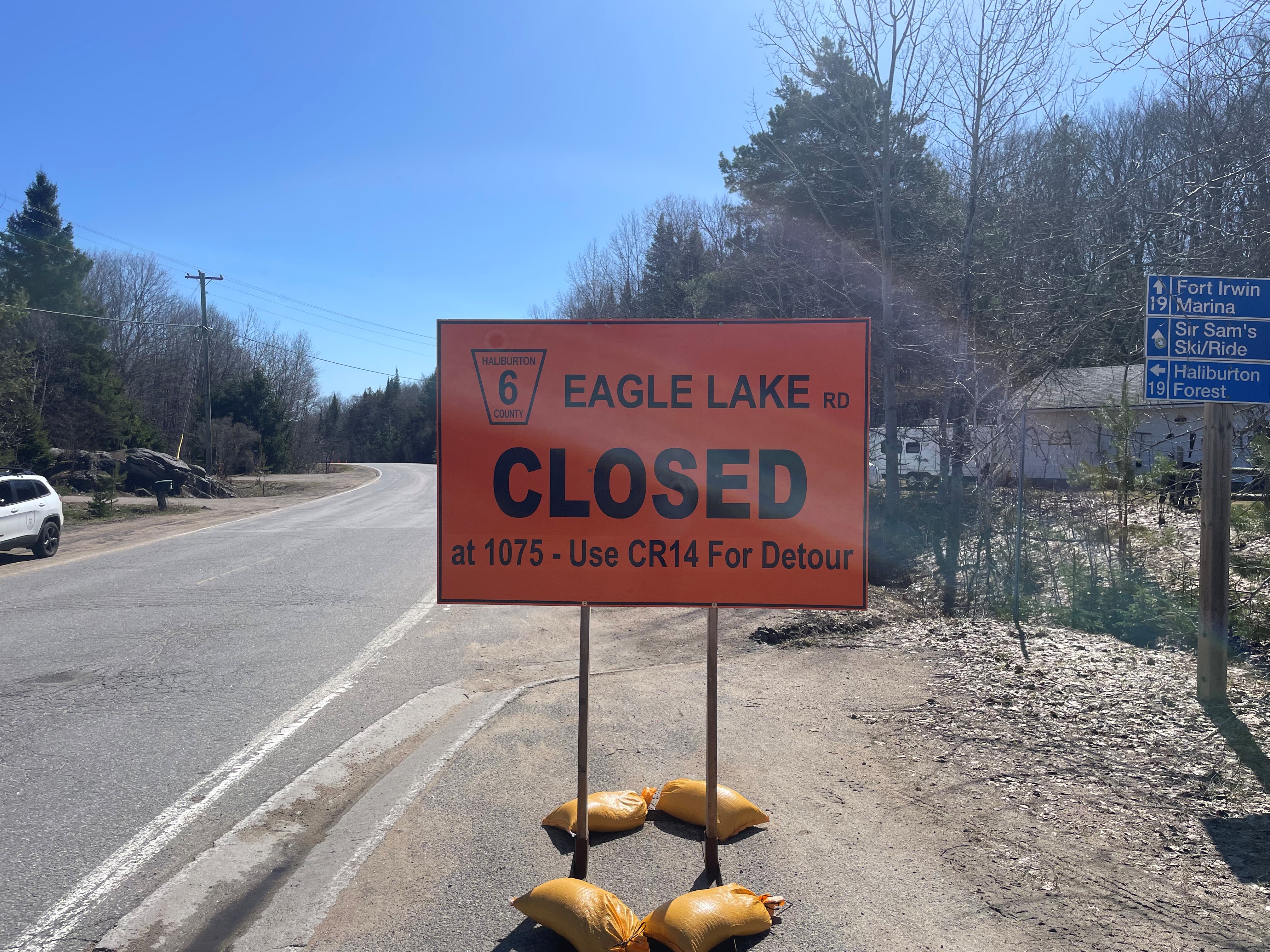 Orange signage indicating road closure on Eagle Lake Road at civic address 1075